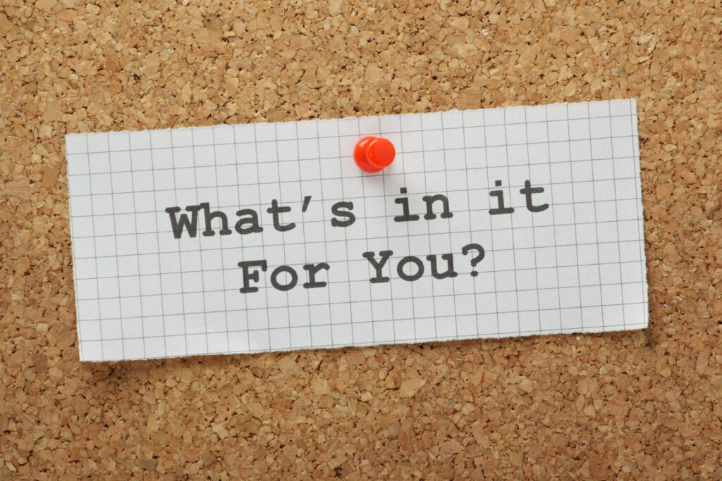 A piece of grid paper pinned to a cork board with the question 'What's in it For You?' written in black marker, inviting reflection on personal benefits or advantages that come with epoxy coatings.