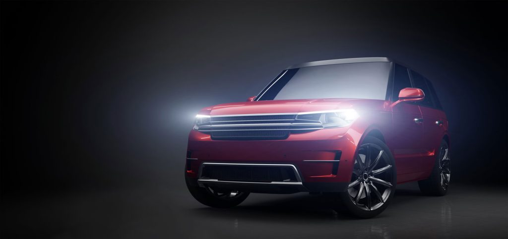 A red modern SUV with sleek design featuring illuminated headlights and shiny alloy wheels, presented in a dimly lit studio setting that highlights its contours and craftsmanship.