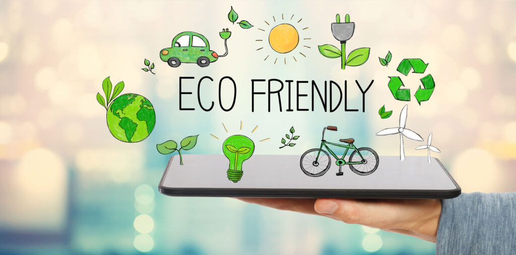 Hand holding a smartphone with doodle icons representing eco-friendly concepts floating above it. The illustrations include the Earth with leaves, a green energy light bulb, a bicycle, wind turbines, a recycling symbol, a solar-powered car, and a plant growing from a power socket, all against a blurred natural background, symbolizing sustainable living and environmental consciousness.